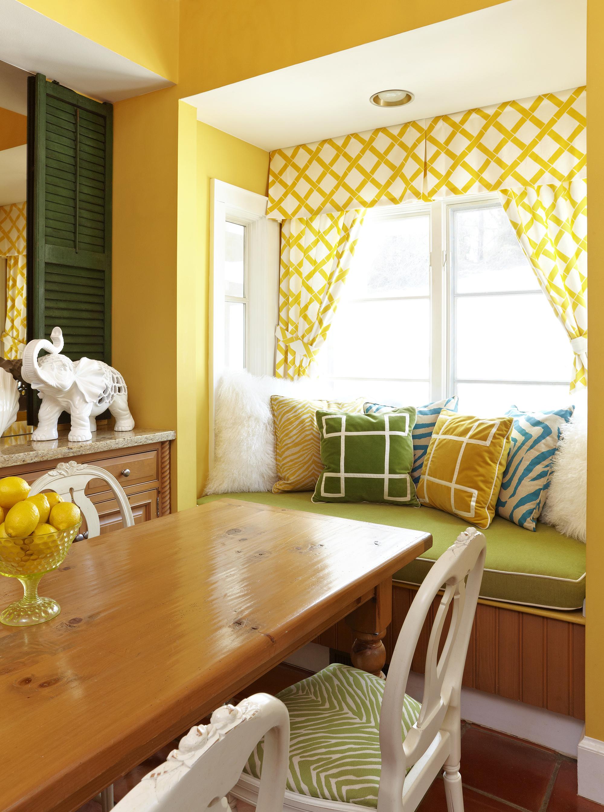 Уютная ниша в столовой с желтыми стенами и шторами